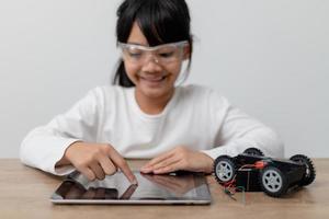 los estudiantes de asia aprenden en casa a codificar autos robot y cables de tableros electrónicos en tallo, vapor, ingeniería matemática, ciencia, tecnología, código de computadora en robótica para el concepto de niños. foto