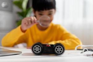 Asia students learn at home in coding robot cars and electronic board cables in STEM, STEAM, mathematics engineering science technology computer code in robotics for kids concept. photo