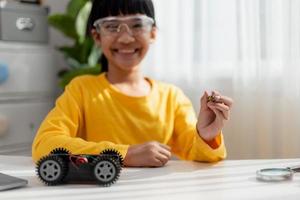 Asia students learn at home in coding robot cars and electronic board cables in STEM, STEAM, mathematics engineering science technology computer code in robotics for kids concept. photo