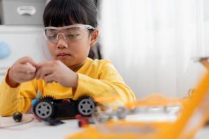 Asia students learn at home in coding robot cars and electronic board cables in STEM, STEAM, mathematics engineering science technology computer code in robotics for kids concept. photo