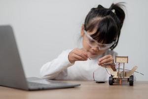 Asia students learn at home in coding robot cars and electronic board cables in STEM, STEAM, mathematics engineering science technology computer code in robotics for kids concept. photo