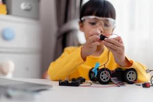 Asia students learn at home in coding robot cars and electronic board cables in STEM, STEAM, mathematics engineering science technology computer code in robotics for kids concept. photo