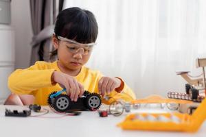 Asia students learn at home in coding robot cars and electronic board cables in STEM, STEAM, mathematics engineering science technology computer code in robotics for kids concept. photo