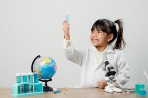 education, science, chemistry and children concept - kids or students with test tube making experiment at school laboratory photo