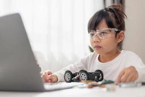 Asia students learn at home in coding robot cars and electronic board cables in STEM, STEAM, mathematics engineering science technology computer code in robotics for kids concept. photo