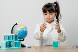 concepto de educación, ciencia, química y niños - niños o estudiantes con tubos de ensayo haciendo experimentos en el laboratorio escolar foto