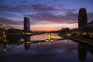 Photo of sunrise over the Main river in Frankfurt with bright morning red which is reflected in the water