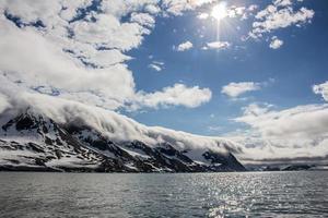 Clouds rolling over ice capped mountains in Svalbard