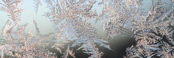 Snowflakes frost rime macro on window glass pane photo