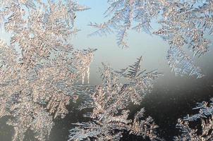 Snowflakes frost rime macro on window glass pane photo