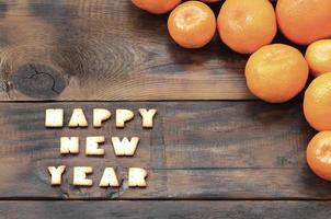 Tangerines, cracker text with copy space on wooden background photo