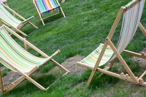 Chaise lounges on a lawn. Garden sunbeds on green grass photo