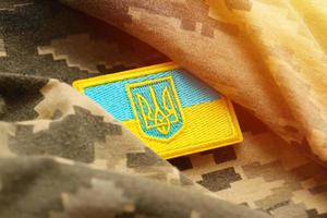 Military camouflage fabric with ukrainian flag on uniform chevron photo