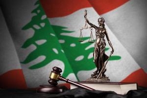 Lebanon flag with statue of lady justice, constitution and judge hammer on black drapery. Concept of judgement and guilt photo