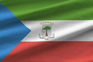 Equatorial Guinea flag with big folds waving close up under the studio light indoors. The official symbols and colors in banner photo