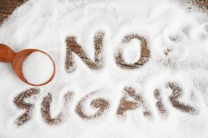 sin azúcar, azúcar granulada dulce con texto, prevención de diabetes, dieta y pérdida de peso para una buena salud. foto