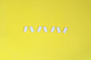 A few chewing gums lie on texture background of fashion pastel yellow color paper in minimal concept photo