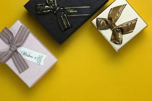 Three Gift Boxes are isolated on yellow background, used in Christmas party concepts and New Year design. photo