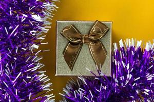 una caja de regalo aislada en bg amarillo. una caja de regalo con cinta de color brillante y lazo. utilizado en el concepto de celebración, pancartas de navidad y año nuevo foto