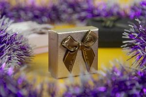 maravillosa caja de regalo dorada con fondo de cintas en bg amarillo, una caja dorada de enfoque. foto