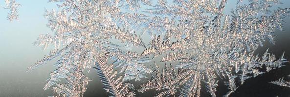 Snowflakes frost rime macro on window glass pane photo