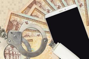 Billetes de 20 pesos dominicanos y smartphone con esposas policiales. concepto de ataques de phishing de piratas informáticos, estafa ilegal o distribución blanda de malware foto