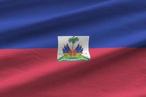 Haiti flag with big folds waving close up under the studio light indoors. The official symbols and colors in banner photo