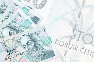 100 Czech korun bills lies in stack on background of big semi-transparent banknote. Abstract business background photo