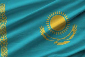 Kazakhstan flag with big folds waving close up under the studio light indoors. The official symbols and colors in banner photo