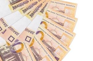 Los billetes de 20 rublos bielorrusos se encuentran aislados en fondo blanco con espacio de copia apilado en forma de abanico de cerca foto