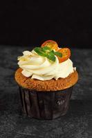 Cupcakes with cheese cream decorated with berries on dark background photo