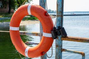 Lifebuoy hanging on the handle of the pier. The concept of saving drowning photo