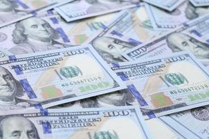 A large number of US dollar bills of a new design with a blue stripe in the middle. Top view photo