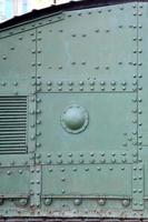 Texture of tank side wall, made of metal and reinforced with a multitude of bolts and rivets photo