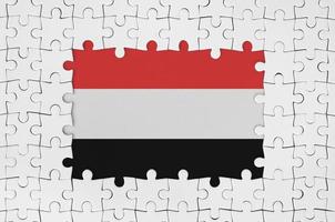 Yemen flag in frame of white puzzle pieces with missing central part photo