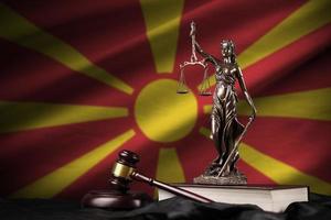 bandera de macedonia con estatua de la dama de la justicia, constitución y martillo de juez sobre cortinas negras. concepto de juicio y culpa foto