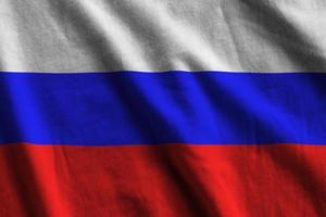 Russia flag with big folds waving close up under the studio light indoors. The official symbols and colors in banner photo