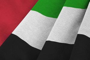 bandera de los emiratos árabes unidos con grandes pliegues ondeando de cerca bajo la luz del estudio en el interior. los símbolos y colores oficiales en banner foto