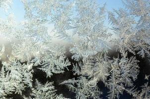 Snowflakes frost rime macro on window glass pane photo