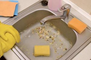 The housekeeper was faced with the problem of washing an overly dirty sink filled with food particles photo