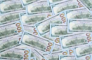 A large number of US dollar bills of a new design with a blue stripe in the middle. Top view photo