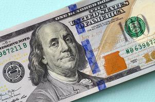 US dollar bills of a new design with a blue stripe in the middle is lies on a light blue background