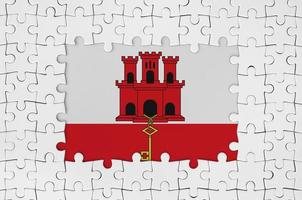 Giblartar flag in frame of white puzzle pieces with missing central part photo