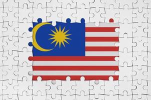 Malaysia flag in frame of white puzzle pieces with missing central part photo