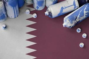 Qatar flag and few used aerosol spray cans for graffiti painting. Street art culture concept