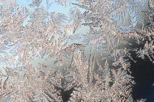 Snowflakes frost rime macro on window glass pane photo