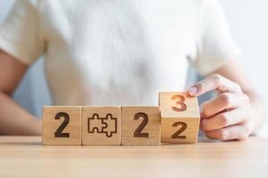woman hand change 2022 to 2023 block with jigsaw puzzle icon. Business Process, Team, teamwork, Goal, mission, Resolution, strategy, plan, Action, partnership, and New Year start photo