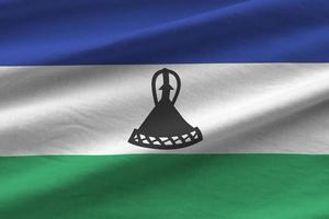 bandera de lesotho con grandes pliegues ondeando de cerca bajo la luz del estudio en el interior. los símbolos y colores oficiales en banner foto