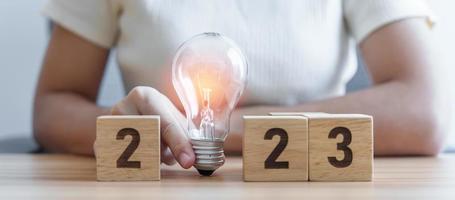 2023 block with lightbulb. Business Idea, Creative, Thinking, brainstorm, Goal, Resolution, strategy, plan, Action, change and New Year start concepts photo