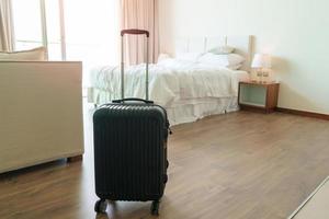 Black Luggage in modern hotel room after door opening. Baggage for Time to travel, service, journey, trip, summer holiday and vacation concepts photo